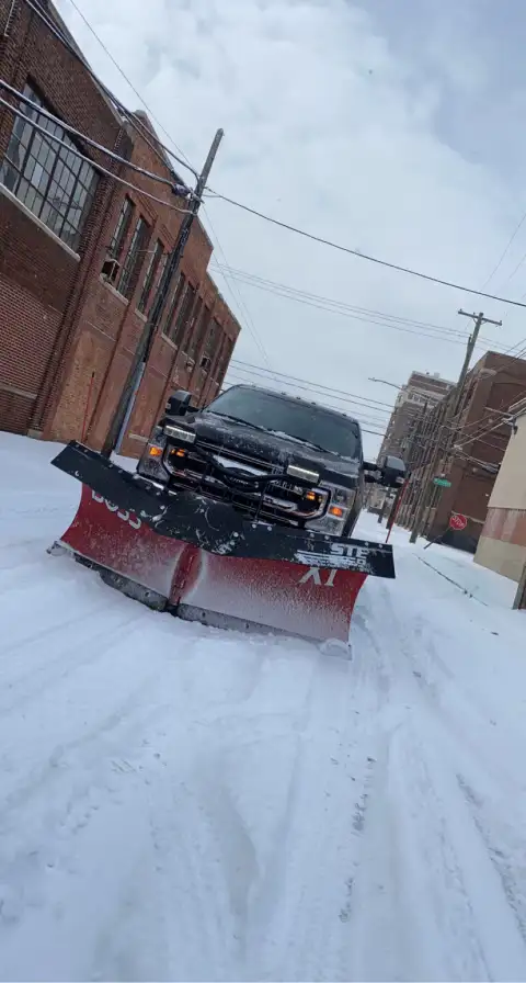 Snow plowing in commercial alley during winter storm
