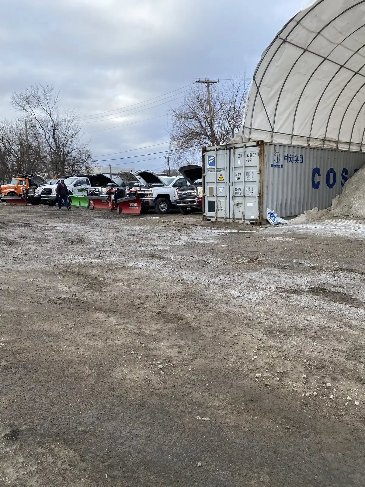 Truck plowing heavy snowfall through a commercial parking lot