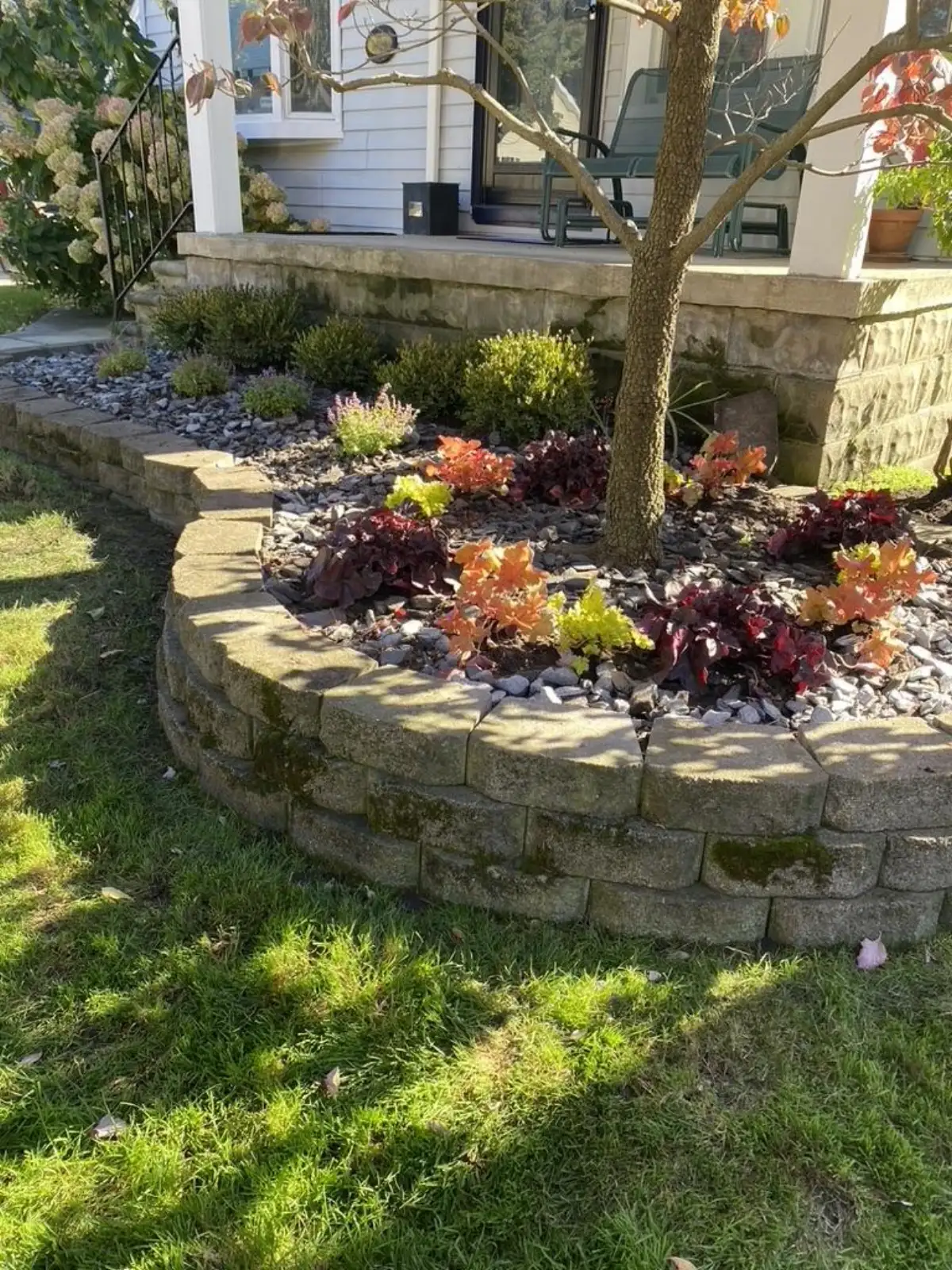 Fresh mulch installation around retaining wall planting bed
