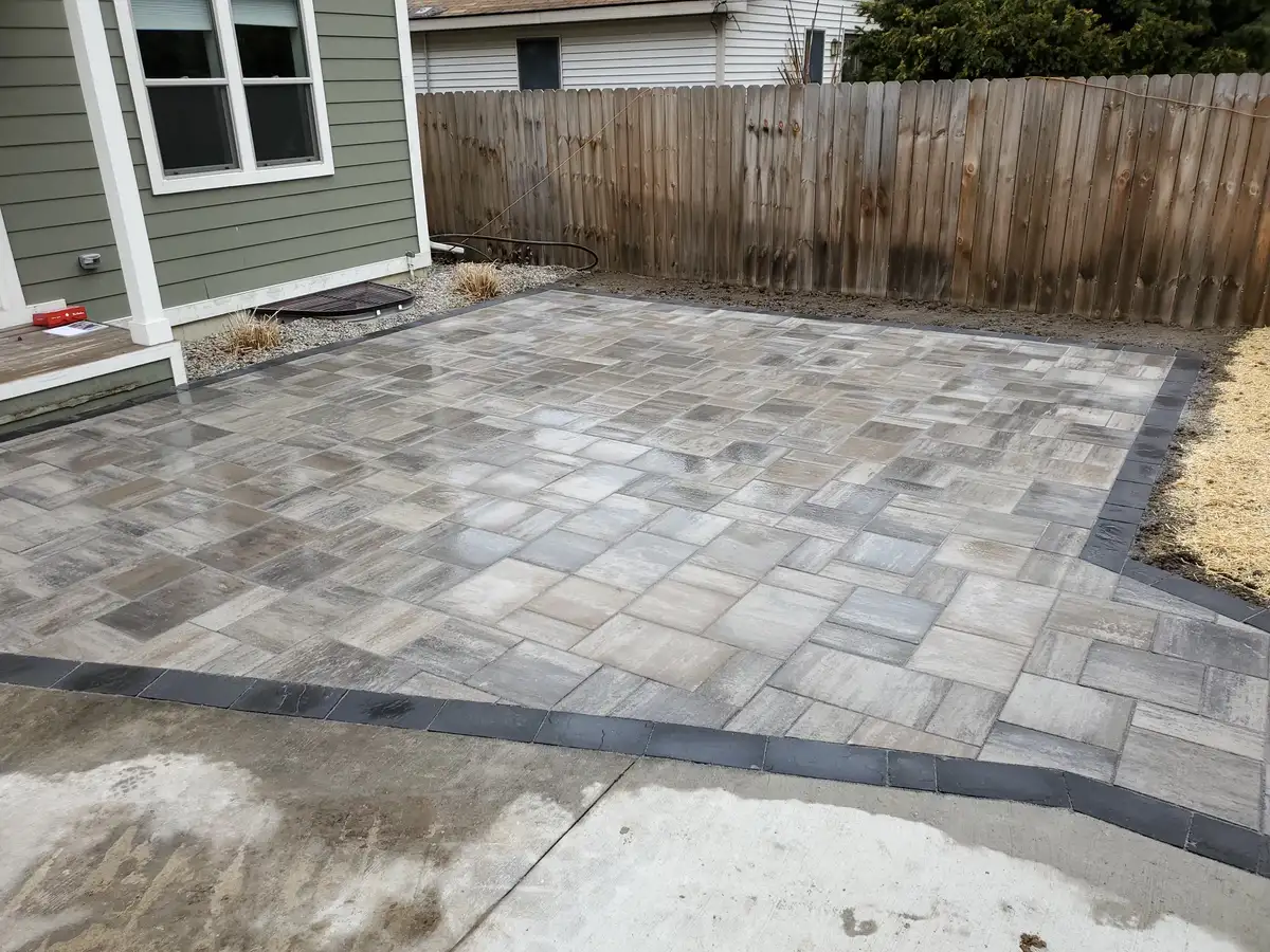 Elevated concrete paver patio with curved steps and outdoor dining area