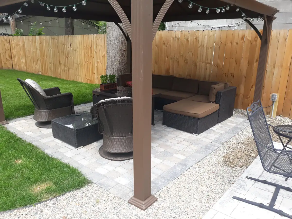 Pergola with string lights over outdoor living room with wicker sectional