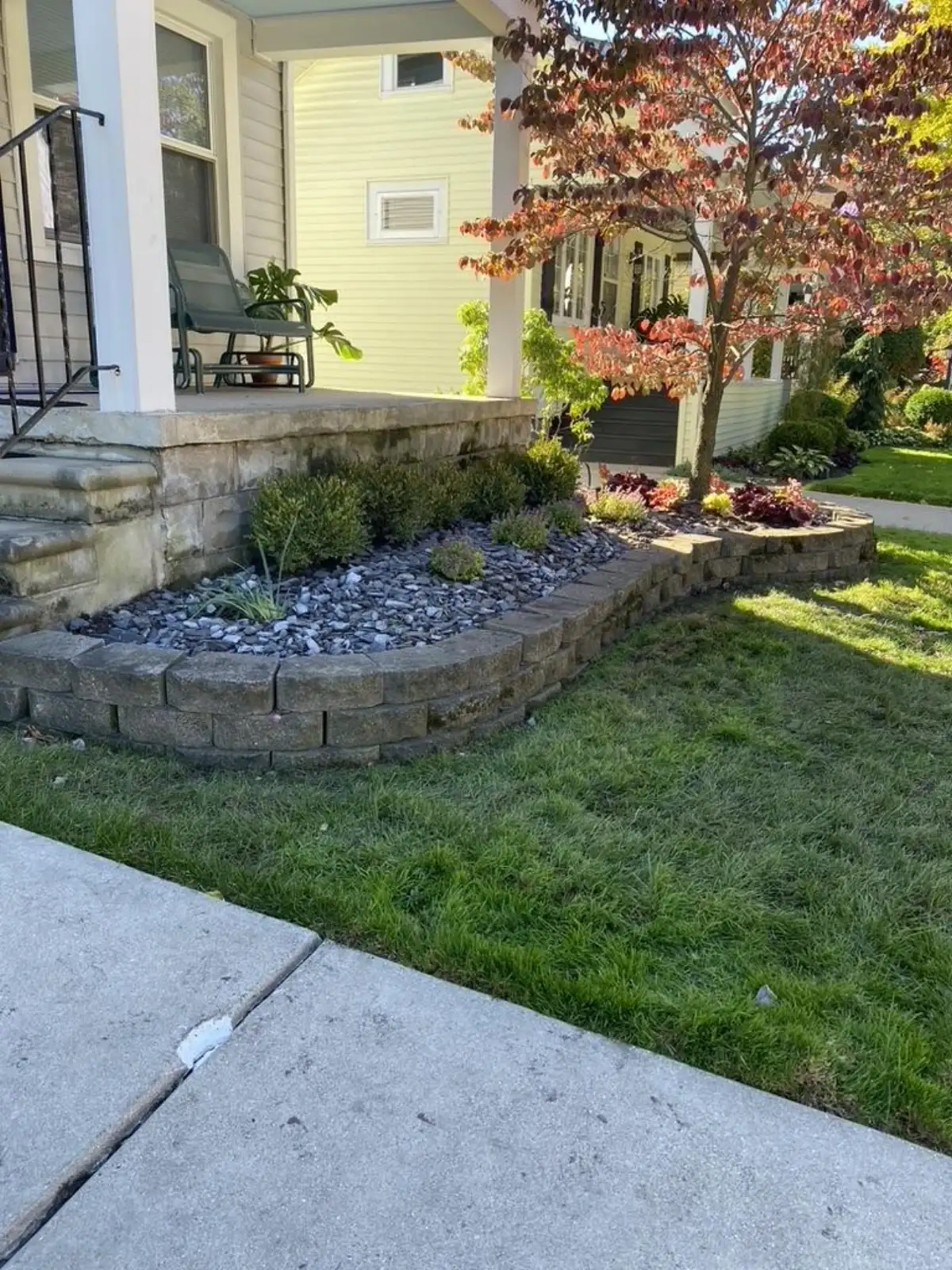 Multi-tier retaining wall creating raised garden beds across entire home front