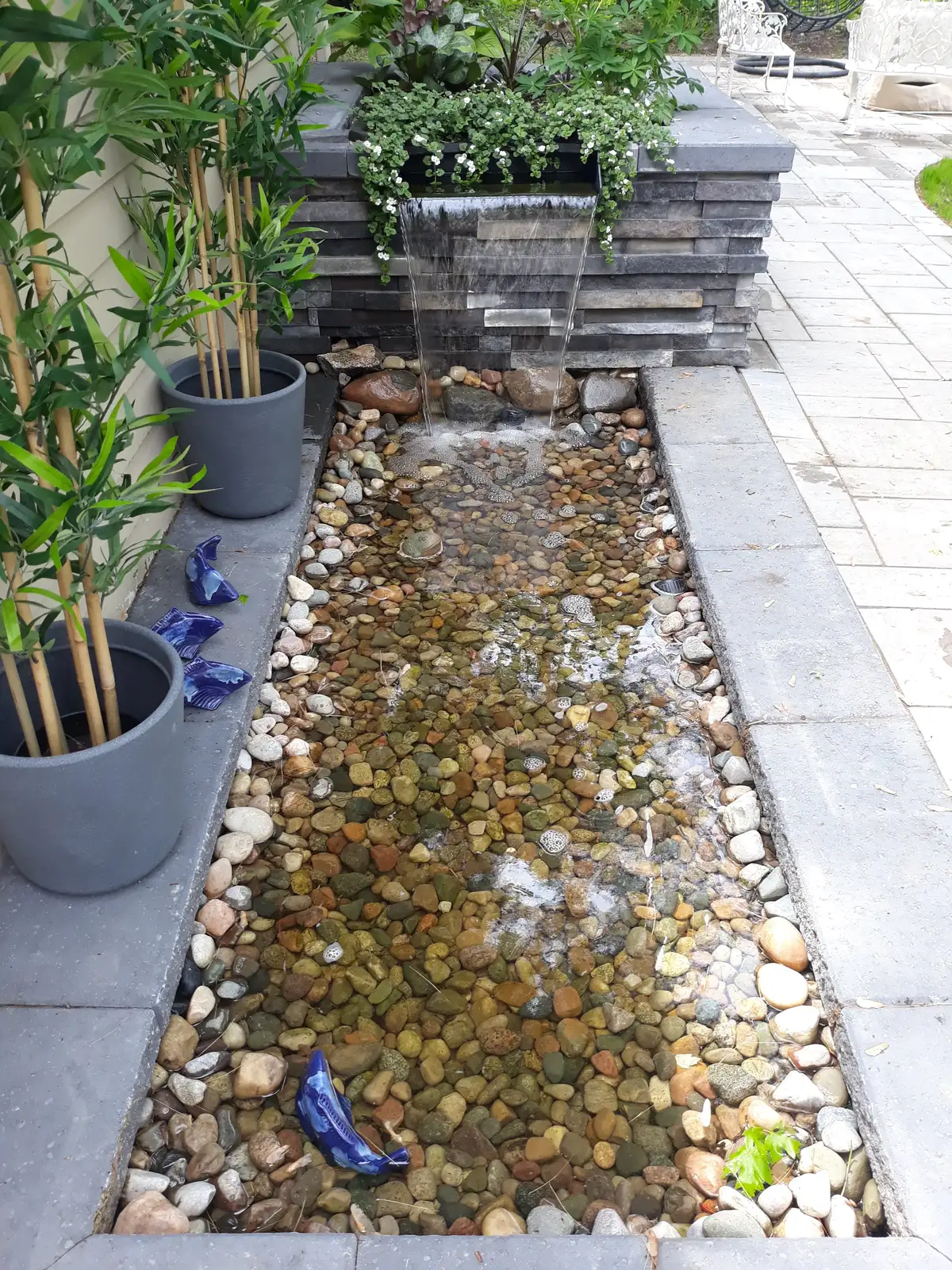 Custom waterfall feature with natural boulders and clean water movement