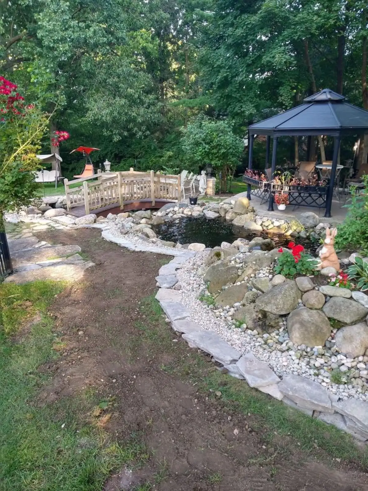 Large naturalistic water garden with aquatic plants and gravel walking path